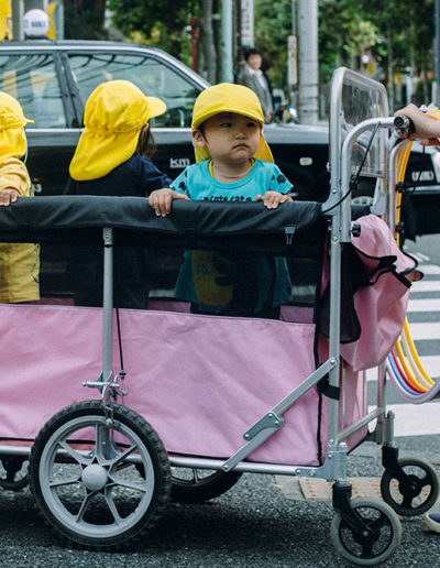 Trois petits enfants dans un chariot rose
